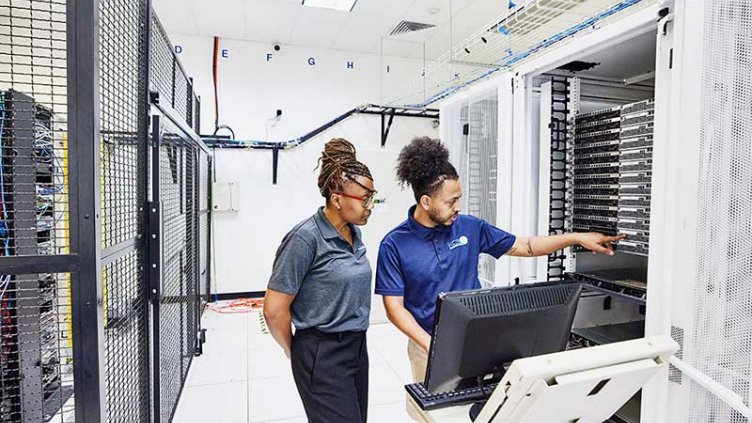 IT professionals in discussion while configuring server in data center